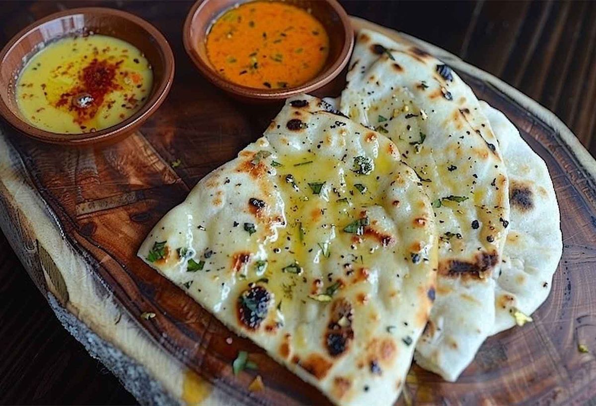 A close-up of popular Indian breads—garlic naan and cheese naan—typically served with rich curries and tandoori dishes at an Indian restaurant in Los Angeles.